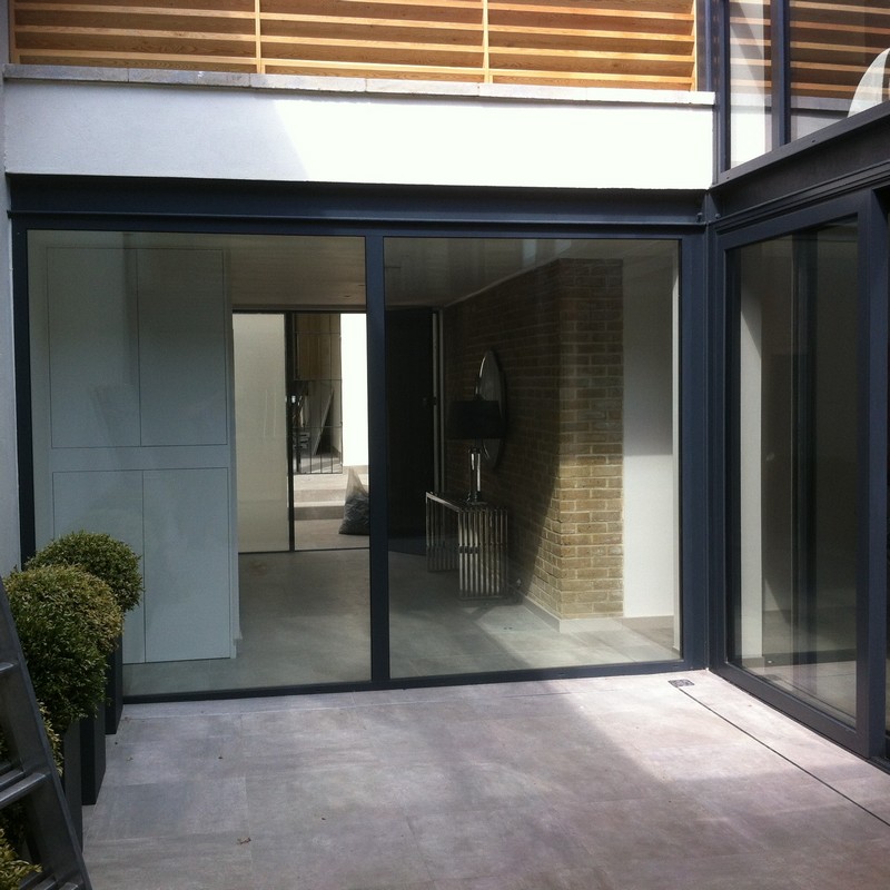 Floor-to-ceiling sliding doors opening to courtyard in Teddington