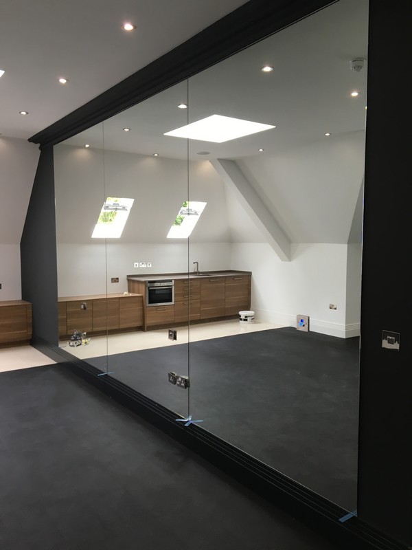 Frameless glass partition in loft conversion by Teddington glaziers